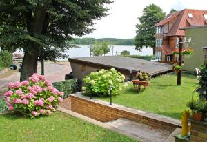 um quintal com flores e uma casa e um lago em Ferienwohnung Lychen UCK 1021 em Lychen