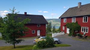a car parked in front of two red houses at Nedre Berg Gard in Lillehammer