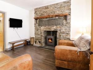 a living room with a stone fireplace and a couch at Arosfa in Bala