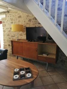 een woonkamer met een tv en een tafel met een tafel sidx sidx sidx sidx bij Le cottage de l'étang in Le Tablier