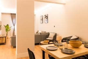 ein Wohnzimmer mit einem Tisch und einem Sofa in der Unterkunft Zabalburu in Bilbao
