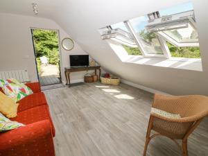 salon z czerwoną kanapą i dwoma oknami w obiekcie Robins Rest w mieście Yelverton