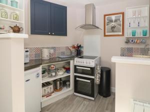 a kitchen with blue cabinets and an open refrigerator at Robins Rest in Yelverton