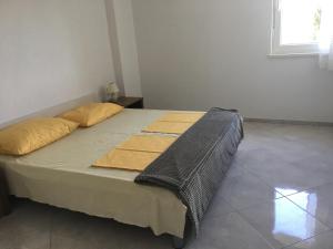 a bedroom with a large bed with yellow pillows at Apartments MiaMaja 2 in Novalja
