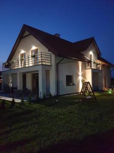 Una casa blanca con luces en el costado. en Villa Bella Italia II en Mikołajki