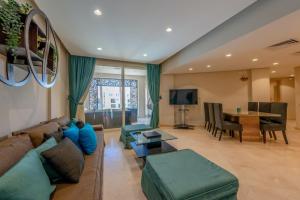 uma sala de estar com um sofá e uma mesa em Mangroovy 3BR Apartment Private Beach & Pool View em Hurghada