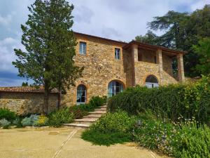 uma casa de pedra com escadas que levam até ela em Tenuta CastelGiocondo em Montalcino