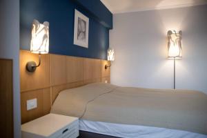 ein Schlafzimmer mit einem Bett und zwei Lampen an der Wand in der Unterkunft Apartament, Ultracentral, Piata Victoriei in Bukarest