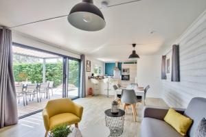 a living room with a couch and a table at Chalet pour 8 dans résidence avec piscine chauffée in Brétignolles-sur-Mer