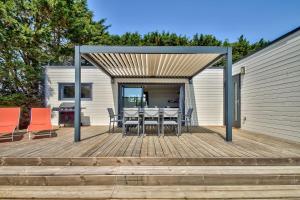 a wooden deck with a table and chairs on it at Chalet pour 8 dans résidence avec piscine chauffée in Brétignolles-sur-Mer