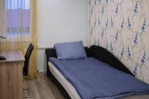 a bedroom with a bed with blue sheets and a desk at Beautiful air-conditioned apartment in the centre in Debrecen