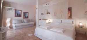 サンピエリにあるPoggio Bellavistaの白いベッドルーム(ベッド1台、ソファ付)