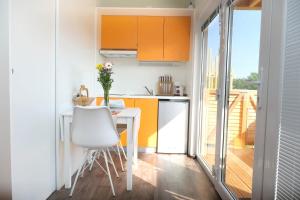 a small kitchen with a white table and chairs at VINEA PANONIKA wine & mind retreat in Radenci