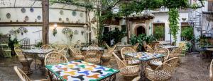 um grupo de mesas e cadeiras num pátio em Hotel América em Granada