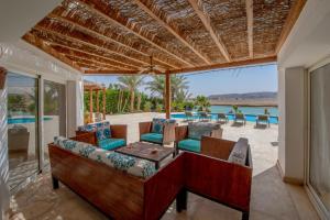 een patio met een bank, stoelen en een tafel bij Beautiful 4 bedroom White Villa with Heated Pool in Hurghada