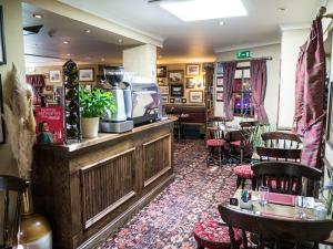 um restaurante com um bar com mesas e cadeiras em The Golf Tavern em Haddington