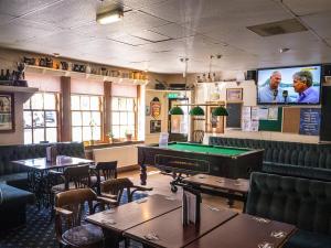 un ristorante con tavolo da biliardo e TV di The Golf Tavern a Haddington