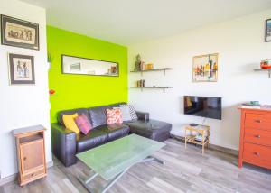 uma sala de estar com um sofá e uma parede verde em Métro 12, Stade De France, Parking, Balcon, 45m2, View, em Aubervilliers