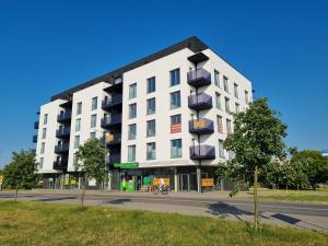 a white building with balconies on a street at Apartament Fredry 2 PREMIUM KLIMA in Kołobrzeg