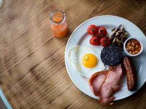 un plato de desayuno con huevos, salchichas y fruta en The Smugglers Rest, en Woolacombe