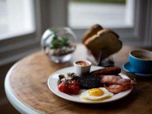 a plate of breakfast food on a wooden table at The Smugglers Rest in Woolacombe