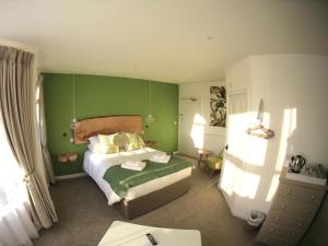 a bedroom with a bed with a green wall at The Smugglers Rest in Woolacombe