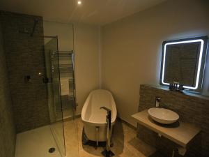 a bathroom with a tub and a sink and a shower at The Smugglers Rest in Woolacombe