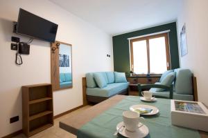 ein Wohnzimmer mit Tisch und Stühlen und einem Fernseher in der Unterkunft Corte Milano in Rozzano