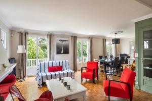 a living room with red chairs and a table at La Déferlante - Maison familiale à Cancale in Cancale