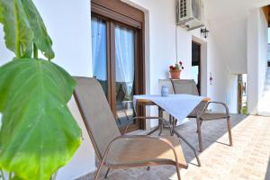 a patio with a table and chairs and a plant at neos panteleimonas pierias VILLA LAYLA in Neos Panteleimonas