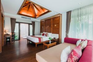a hotel room with a bed and a couch at Railay Village Resort in Railay Beach