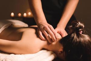 a woman getting a back massage from a therapist at SETTANNI Sea Suites in Polignano a Mare