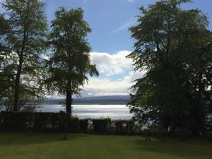 a field with trees and a body of water at Old Drynie House, in Inverness