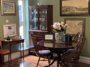 a dining room with a table with flowers on it at Old Drynie House, in Inverness