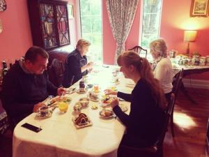 a group of people sitting around a table eating food at Old Drynie House, in Inverness