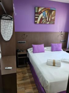 een hotelkamer met een groot bed met paarse muren bij Hotel TossaMar in Tossa de Mar