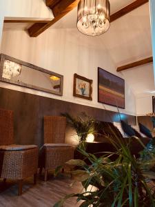 a lobby with chairs and a tv and a chandelier at B&B Prachtig Allemachtig in Valkenburg