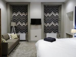 um quarto de hotel com uma cama e um sofá em Edinburgh Nine em Edinburgo
