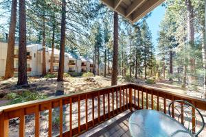 a deck with a table and chairs and trees at Tahome & Tahoe Place in Incline Village