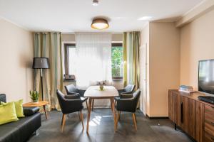 a living room with a table and chairs at Ostsee Elmenhorst Sehr hochwertige Dreizimmer Ferienwohnung mit Gartenterrasse in Elmenhorst