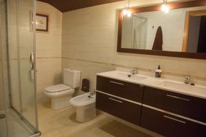 een badkamer met een toilet, een wastafel en een spiegel bij Sorkun in Lacunza