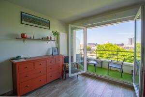 a bedroom with a dresser and a balcony with a view at Métro 12, Stade De France, Parking, Balcon, 45m2, View, in Aubervilliers