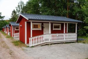 a row of red houses on a dirt road at Maja Camping in Bottnaryd