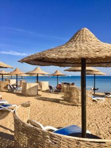 ein Strand mit Stühlen und Sonnenschirmen und das Meer in der Unterkunft سهل حشيش in Hurghada