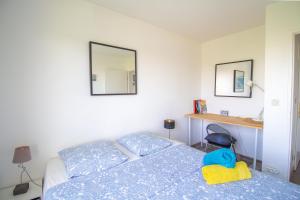 a bedroom with a bed and a desk with a mirror at Métro 12, Stade De France, Parking, Balcon, 45m2, View, in Aubervilliers