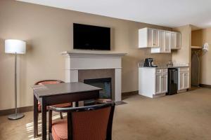 a living room with a fireplace and a tv on the wall at Quality Inn & Suites Amsterdam in Saint John