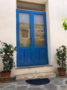une porte bleue sur une maison avec deux plantes en pot dans l'établissement Il Cortiletto - Lipari CENTRO, à Lipari