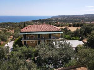 a house on a hill with the ocean in the background at Apsedes Studios in Trapezaki