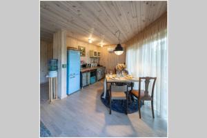 a kitchen with a table and a blue refrigerator at Guest house Lilac in apple tree park in Nākotne
