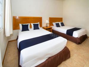 a hotel room with two beds with blue and white sheets at Hotel La Casa de Don Tito, Jocotitlan in Jocotitlán